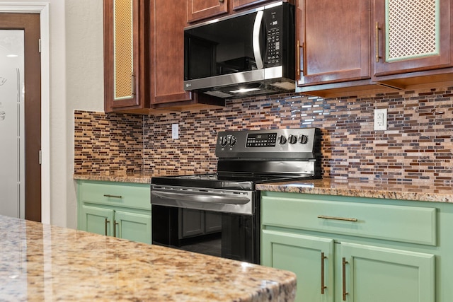 4909 Calle Espana NW, Albuquerque, NM 87120 - kitchen featuring range with electric cooktop, stainless steel microwave, and decorative backsplash