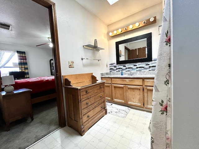 668 Helen Cir, Los Lunas, NM 87031 - bathroom featuring a textured ceiling, vaulted ceiling, vanity, backsplash, and ensuite bathroom
