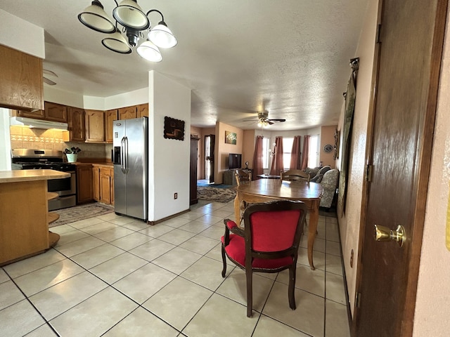 668 Helen Cir, Los Lunas, NM 87031 - kitchen with stainless steel appliances, backsplash, under cabinet range hood, a chandelier, and open floor plan