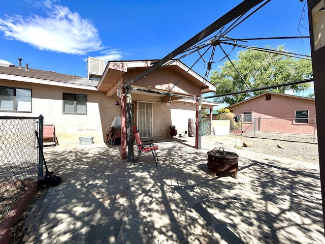668 Helen Cir, Los Lunas, NM 87031 - rear view of house with an outdoor fire pit, fence, stucco siding, and a patio area