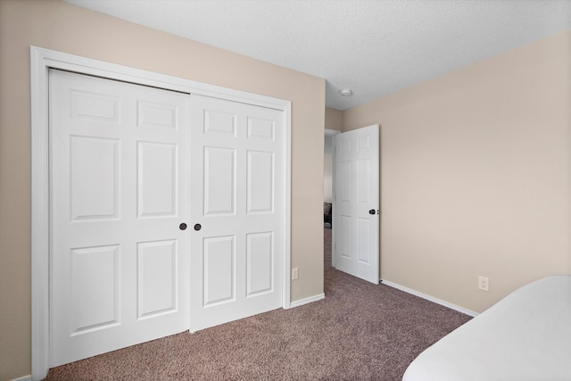 3129 Cochiti St NE, Rio Rancho, NM 87144 - unfurnished bedroom with carpet, a closet, baseboards, and a textured ceiling