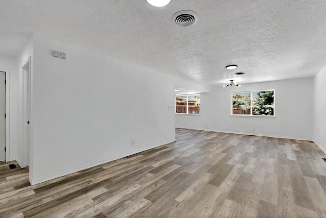357 Meade Ct, Rio Communities, NM 87002 - unfurnished living room featuring wood finished floors, a textured ceiling, and baseboards