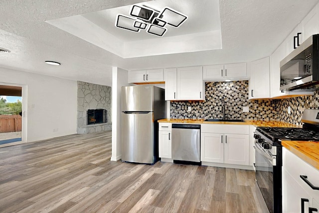 357 Meade Ct, Rio Communities, NM 87002 - kitchen featuring appliances with stainless steel finishes, a sink, butcher block countertops, light wood-style flooring, and white cabinets