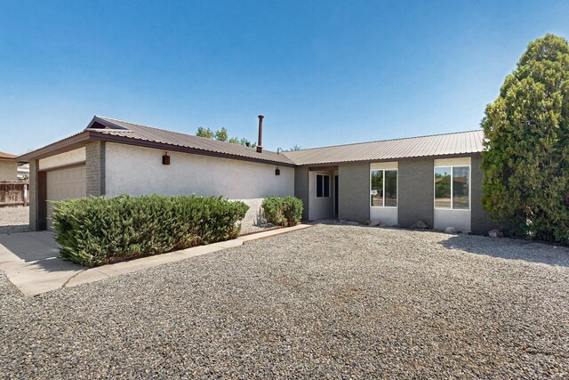357 Meade Ct, Rio Communities, NM 87002 - single story home with a garage, metal roof, brick siding, and stucco siding