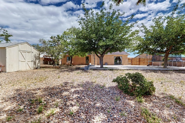 6242 Roadrunner Loop NE, Rio Rancho, NM 87144 - view of yard with a trampoline, a storage shed, fence, and an outbuilding