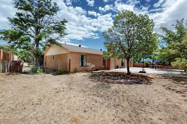 6242 Roadrunner Loop NE, Rio Rancho, NM 87144 - view of front of property with a trampoline, fence, and a patio