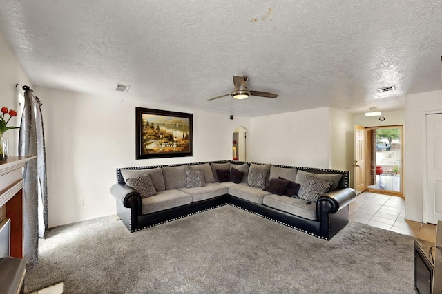 6242 Roadrunner Loop NE, Rio Rancho, NM 87144 - tiled living room featuring arched walkways, a ceiling fan, a textured ceiling, carpet, and a fireplace