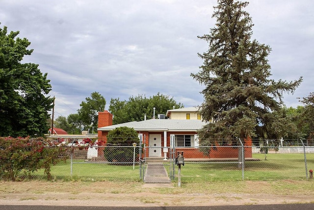 2701 Chapulin Rd SW, Albuquerque, NM 87105 - view of front of home featuring a chimney, a fenced front yard, and brick siding