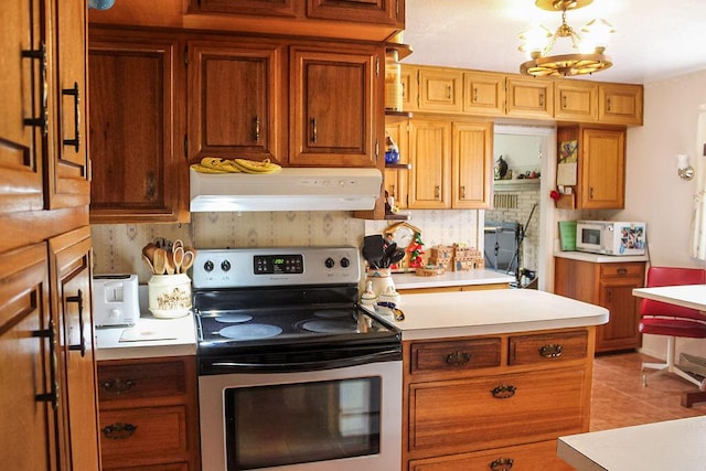 2701 Chapulin Rd SW, Albuquerque, NM 87105 - kitchen with custom exhaust hood, stainless steel electric range oven, light countertops, white microwave, and brown cabinets