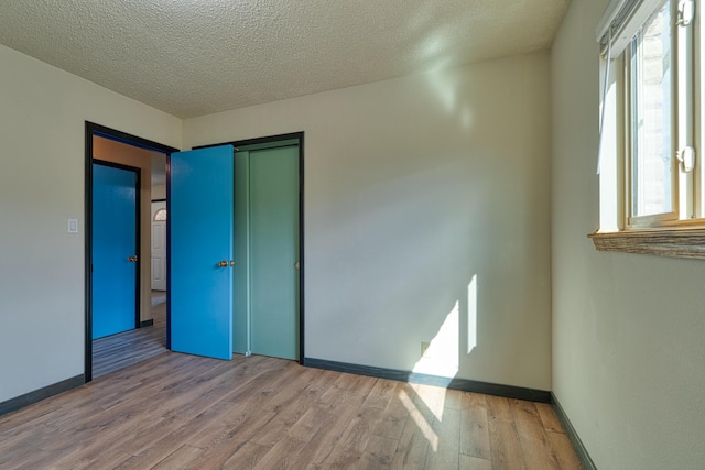 508 Las Marias Dr SE, Rio Rancho, NM 87124 - unfurnished room featuring wood finished floors, plenty of natural light, baseboards, and a textured ceiling