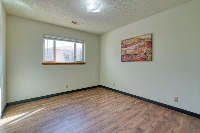 508 Las Marias Dr SE, Rio Rancho, NM 87124 - empty room featuring wood finished floors, a textured ceiling, and baseboards