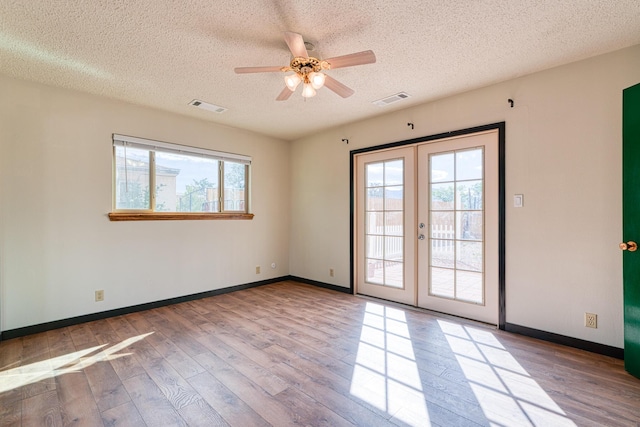 508 Las Marias Dr SE, Rio Rancho, NM 87124 - unfurnished room featuring french doors, wood finished floors, a textured ceiling, a ceiling fan, and baseboards