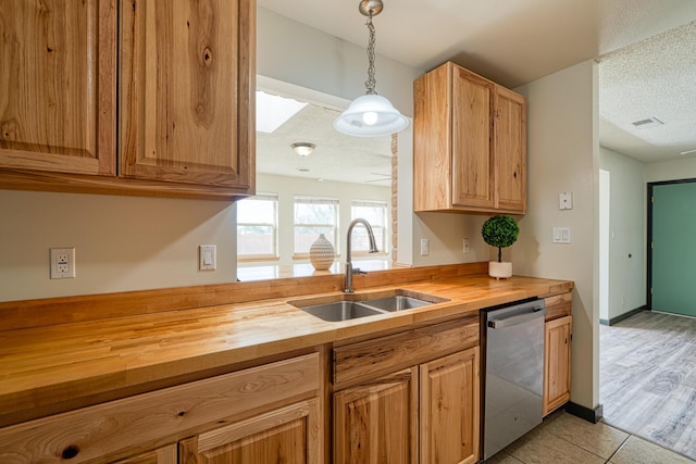508 Las Marias Dr SE, Rio Rancho, NM 87124 - kitchen featuring butcher block countertops, dishwasher, a sink, light tile patterned floors, and a textured ceiling
