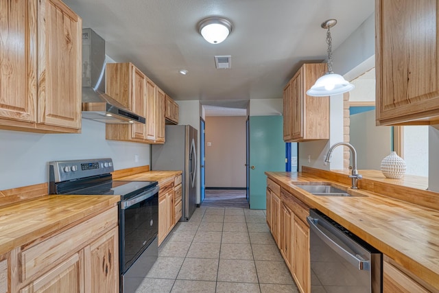 508 Las Marias Dr SE, Rio Rancho, NM 87124 - kitchen featuring butcher block countertops, appliances with stainless steel finishes, wall chimney range hood, a sink, and light tile patterned floors