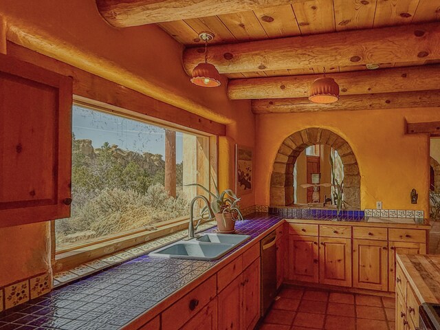 33 Kestrel Rd, Ramah, NM 87321 - kitchen featuring a sink, stainless steel dishwasher, tile countertops, beamed ceiling, and decorative light fixtures