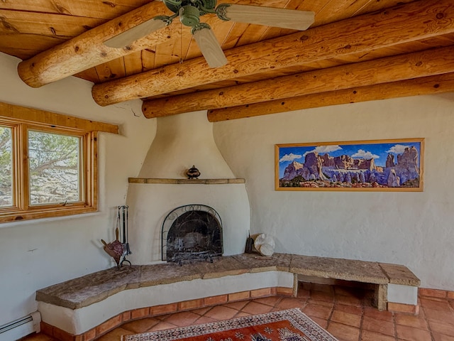 33 Kestrel Rd, Ramah, NM 87321 - living room featuring a baseboard radiator, wooden ceiling, beamed ceiling, a large fireplace, and a ceiling fan