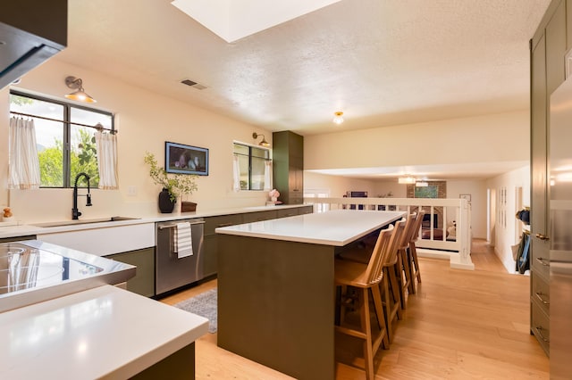7416 Don Tomas Ln NE, Albuquerque, NM 87109 - kitchen with dishwasher, a sink, a kitchen island, light wood-type flooring, and light countertops