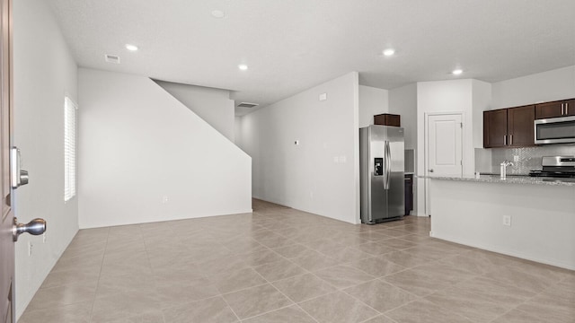 5523 Sagan Loop SE, Albuquerque, NM 87106 - kitchen with appliances with stainless steel finishes, dark brown cabinetry, decorative backsplash, recessed lighting, and light stone countertops