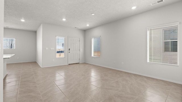 5523 Sagan Loop SE, Albuquerque, NM 87106 - empty room featuring light tile patterned flooring, plenty of natural light, recessed lighting, a textured ceiling, and baseboards