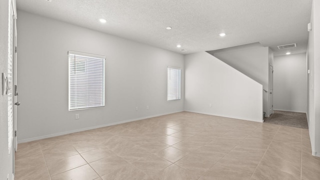 5523 Sagan Loop SE, Albuquerque, NM 87106 - empty room with healthy amount of natural light, a textured ceiling, recessed lighting, light tile patterned flooring, and baseboards
