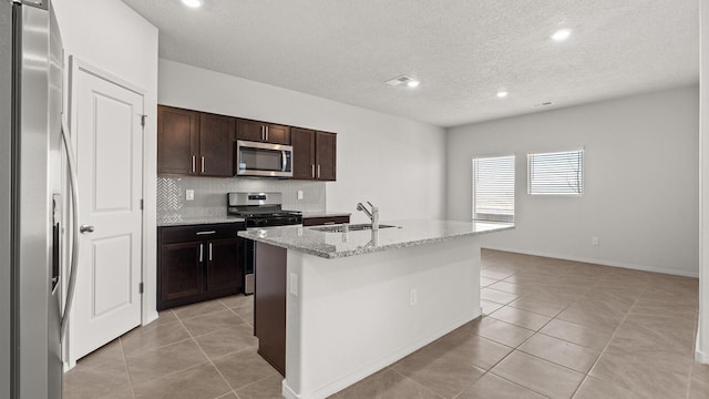 5523 Sagan Loop SE, Albuquerque, NM 87106 - kitchen featuring stainless steel appliances, a sink, light tile patterned floors, a textured ceiling, and decorative backsplash