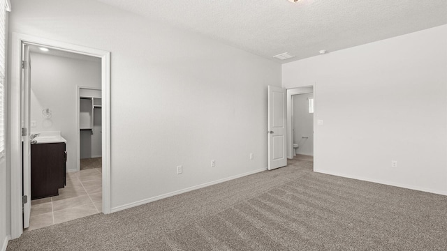 5523 Sagan Loop SE, Albuquerque, NM 87106 - unfurnished bedroom with a spacious closet, light carpet, a textured ceiling, and baseboards