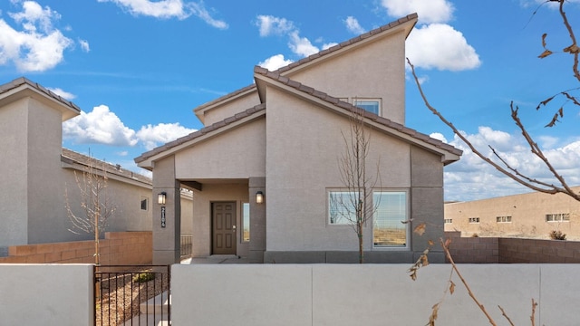 5523 Sagan Loop SE, Albuquerque, NM 87106 - back of house with stucco siding, a tiled roof, and a gate