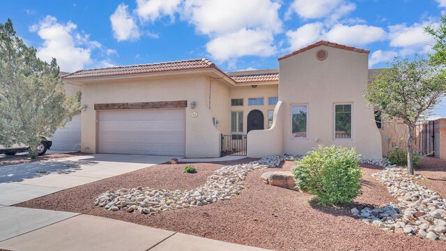 513 Taylor Rd NE, Los Lunas, NM 87031 - mediterranean / spanish home featuring a tile roof, fence, a garage, driveway, and stucco siding