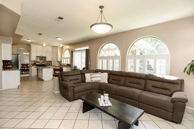 9301 Holm Bursun Dr NW, Albuquerque, NM 87114 - living area with healthy amount of natural light, light tile patterned floors, and arched walkways