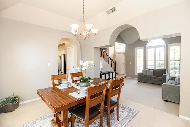 9301 Holm Bursun Dr NW, Albuquerque, NM 87114 - dining room with arched walkways, light carpet, stairway, and a chandelier
