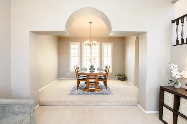 9301 Holm Bursun Dr NW, Albuquerque, NM 87114 - dining space with light carpet, arched walkways, and a chandelier