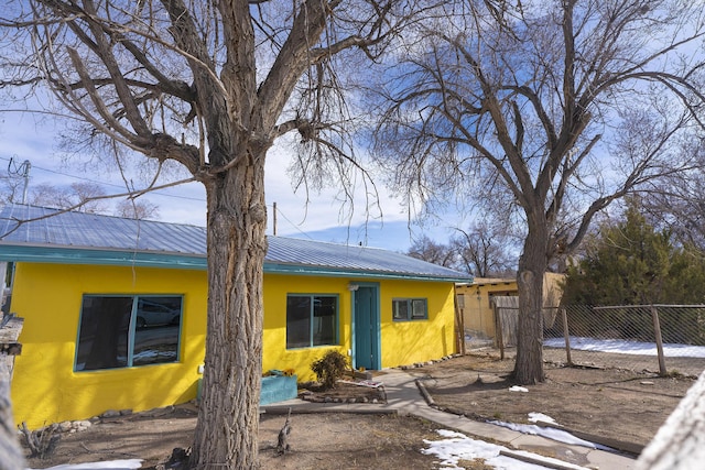 314 S 9th Ave, Estancia, NM 87016 - view of front of property featuring fence, stucco siding, and metal roof