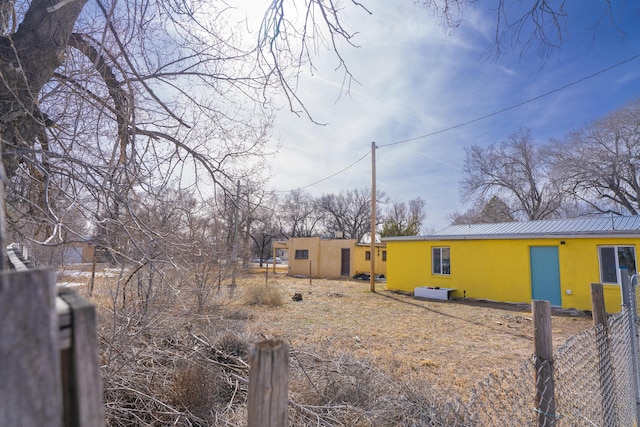 314 S 9th Ave, Estancia, NM 87016 - view of side of property with stucco siding, metal roof, and fence