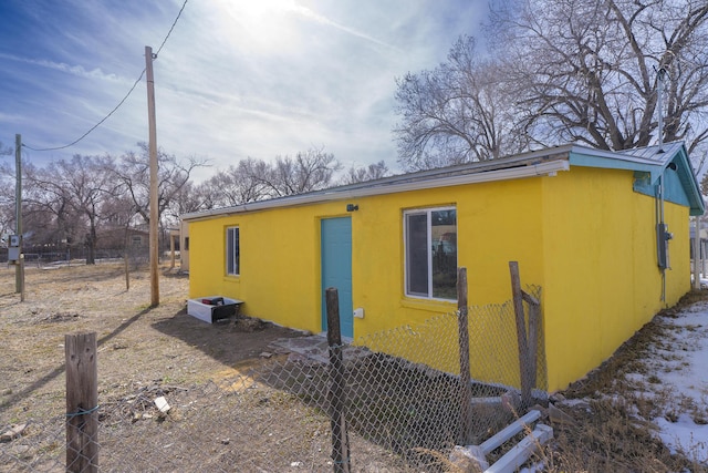 314 S 9th Ave, Estancia, NM 87016 - view of side of property with fence, stucco siding, and metal roof