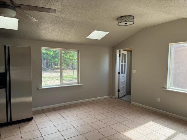 2327 Pajarito Rd SW, Albuquerque, NM 87105 - empty room with a skylight, lofted ceiling, a textured ceiling, a ceiling fan, and light tile patterned floors