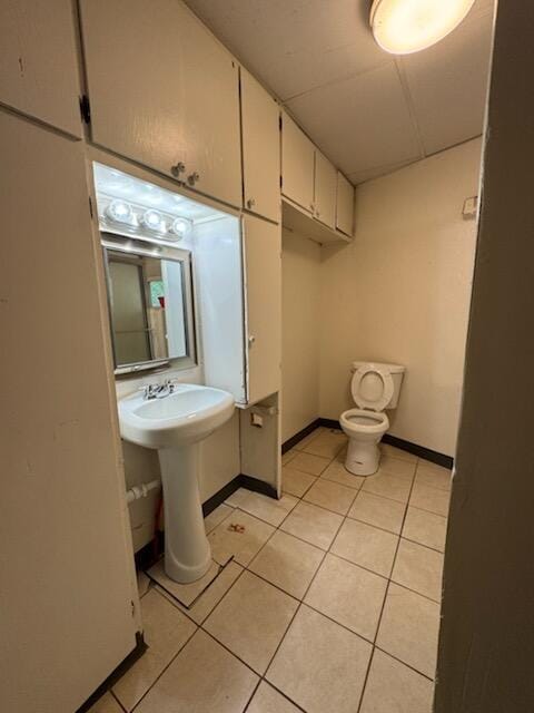 2327 Pajarito Rd SW, Albuquerque, NM 87105 - half bath with tile patterned floors, toilet, a sink, and baseboards