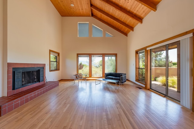 3121 Grande Vista Pl NW, Albuquerque, NM 87120 - unfurnished living room featuring wooden ceiling with exposed beams, wood-type flooring, a brick fireplace, and high vaulted ceiling