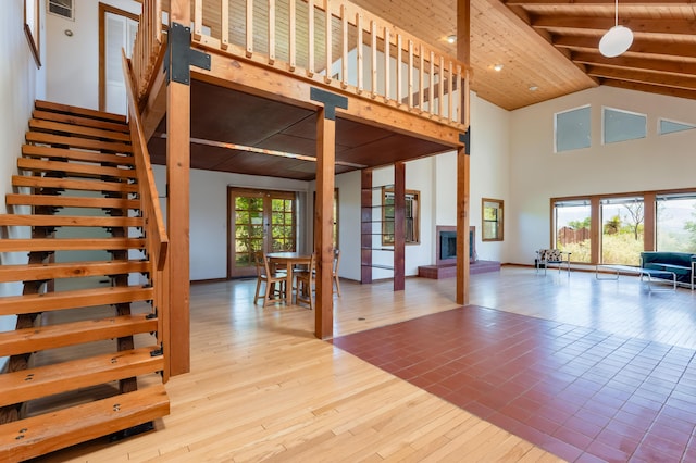 3121 Grande Vista Pl NW, Albuquerque, NM 87120 - unfurnished living room featuring french doors, high vaulted ceiling, wood-type flooring, stairs, and wooden ceiling with exposed beams