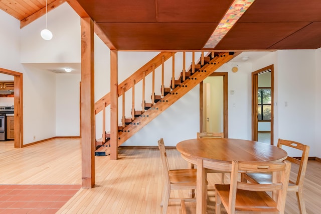 3121 Grande Vista Pl NW, Albuquerque, NM 87120 - dining room with wood finished floors, stairway, wood ceiling with exposed beams, and baseboards