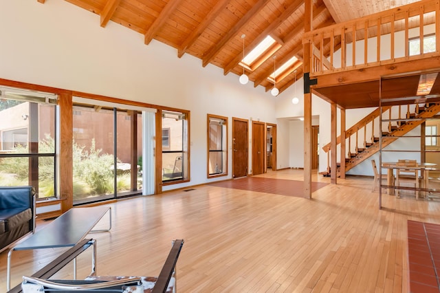 3121 Grande Vista Pl NW, Albuquerque, NM 87120 - unfurnished living room with high vaulted ceiling, stairs, wooden ceiling with exposed beams, and hardwood / wood-style flooring