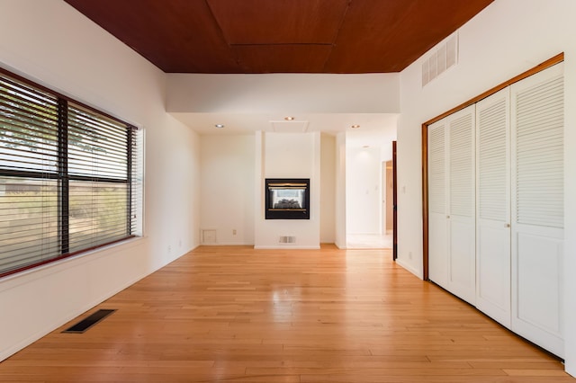 3121 Grande Vista Pl NW, Albuquerque, NM 87120 - unfurnished bedroom with light wood-type flooring, a closet, and a glass covered fireplace