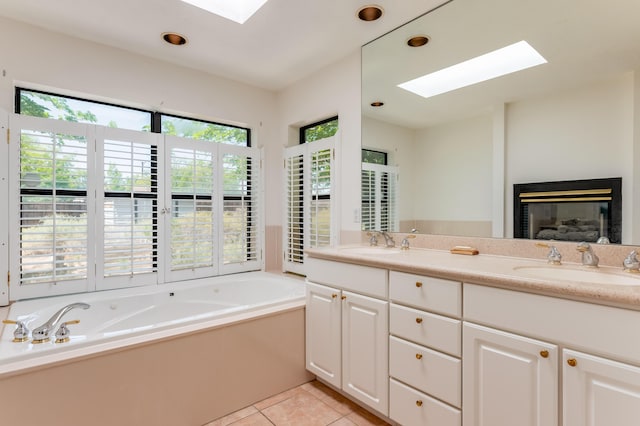 3121 Grande Vista Pl NW, Albuquerque, NM 87120 - full bathroom with a skylight, double vanity, a bath, a glass covered fireplace, and tile patterned flooring