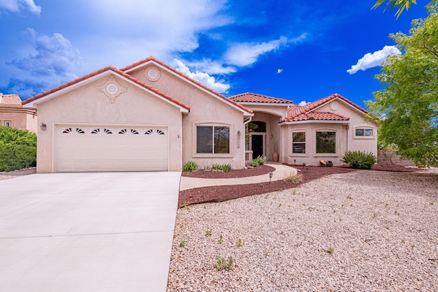 2392 Manzano Loop NE, Rio Rancho, NM 87144 - mediterranean / spanish home featuring a garage, concrete driveway, a tile roof, and stucco siding