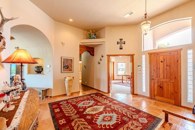 2392 Manzano Loop NE, Rio Rancho, NM 87144 - tiled foyer featuring arched walkways, a high ceiling, baseboards, and recessed lighting