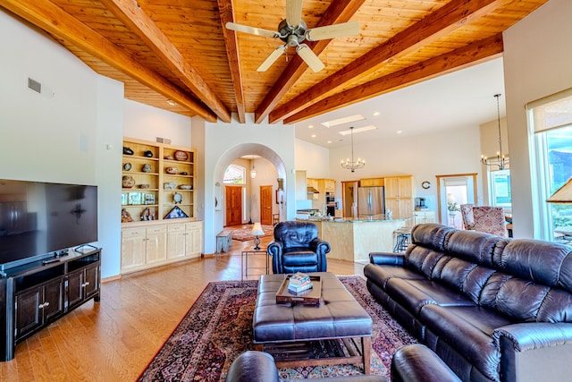 2392 Manzano Loop NE, Rio Rancho, NM 87144 - living room featuring beamed ceiling, a chandelier, a ceiling fan, light wood-type flooring, and wood ceiling
