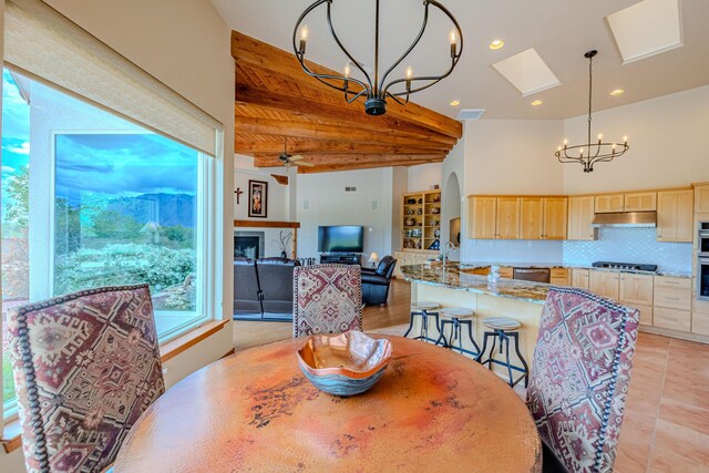 2392 Manzano Loop NE, Rio Rancho, NM 87144 - dining area featuring a chandelier, beam ceiling, light tile patterned floors, a skylight, and recessed lighting
