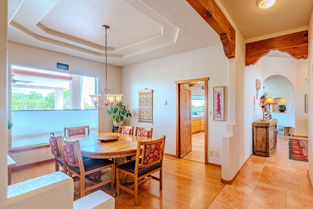 2392 Manzano Loop NE, Rio Rancho, NM 87144 - dining room with arched walkways, healthy amount of natural light, a chandelier, and a tray ceiling