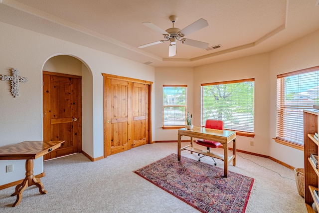 2392 Manzano Loop NE, Rio Rancho, NM 87144 - office area featuring a tray ceiling, light carpet, a ceiling fan, arched walkways, and baseboards