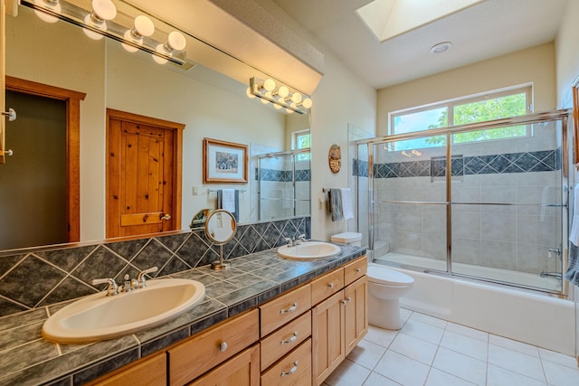 2392 Manzano Loop NE, Rio Rancho, NM 87144 - full bathroom with tile patterned floors, a skylight, toilet, combined bath / shower with glass door, and double vanity