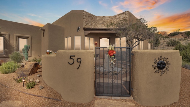 59 Sky Mountain Rd, Placitas, NM 87043 - pueblo-style home with a gate, stucco siding, and fence